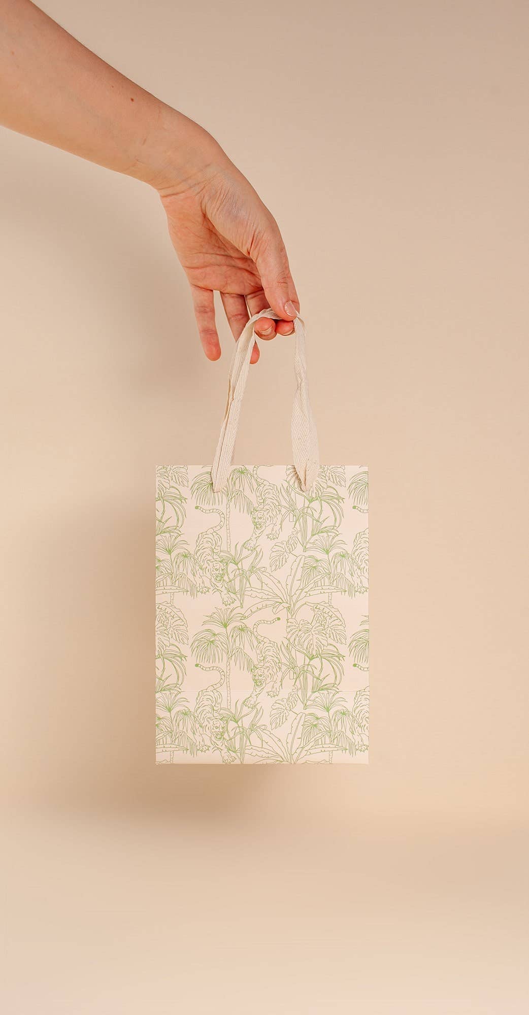 Pale green, jungle print gift bag by Cai & Jo is plastic-free and zero waste. Nontoxic, plastic-free, reusable, and includes speckled cotton handles.