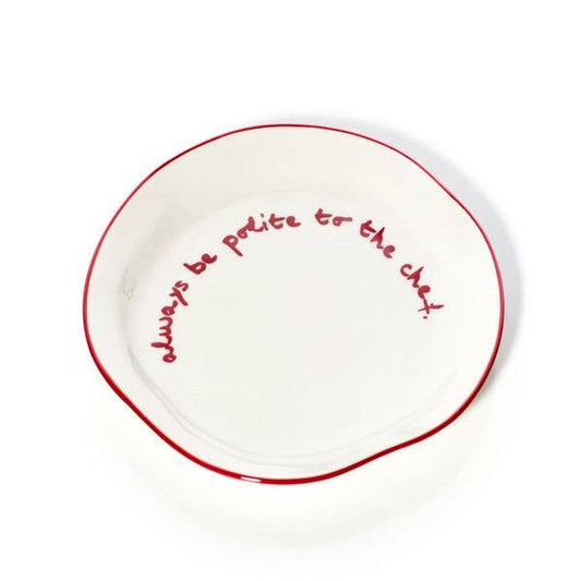 White plate with red  rim and red text 'always be polite to the chef'