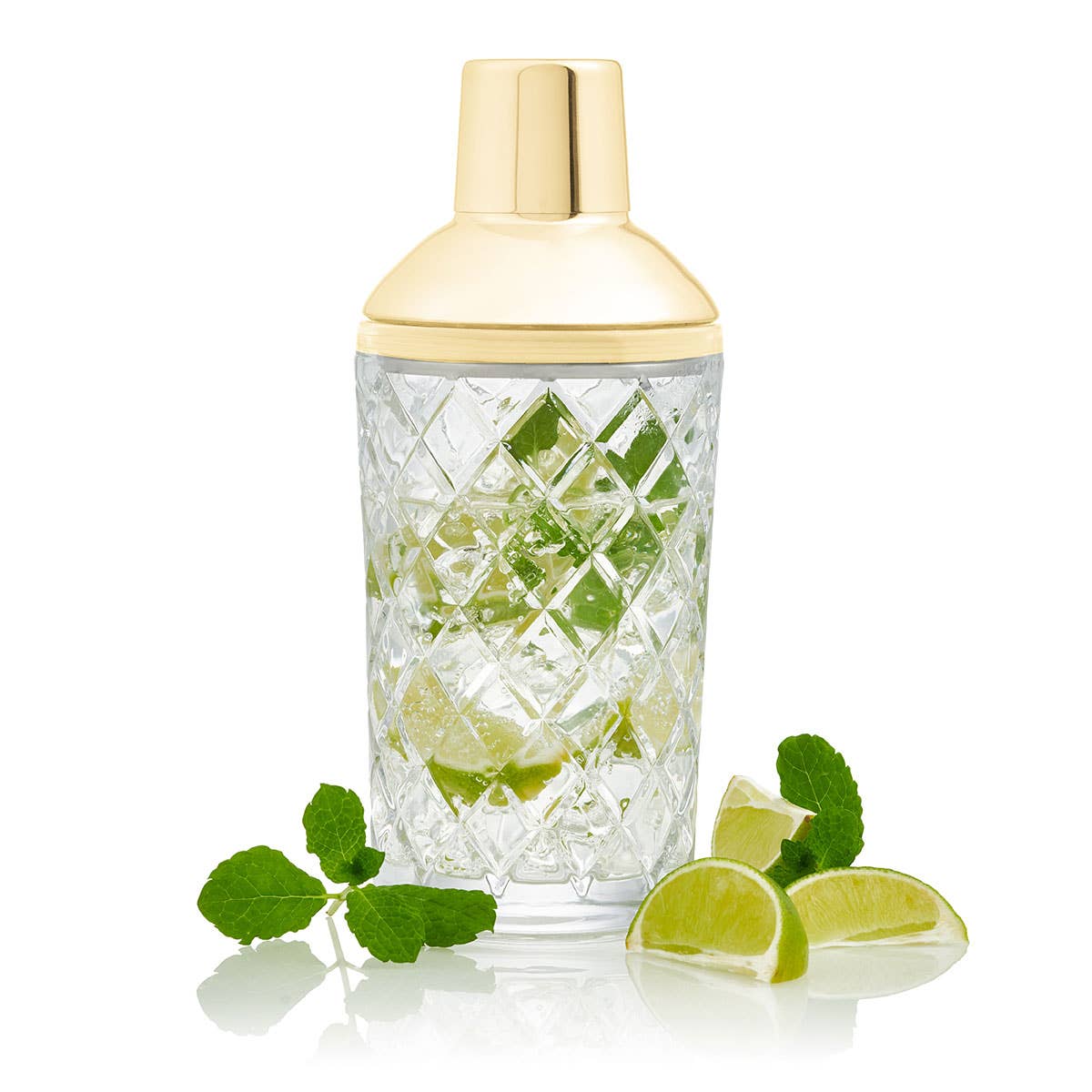 Large cut glass cocktail shaker with gold colour top by Uberstar filled with cocktail and limes and mint leaves