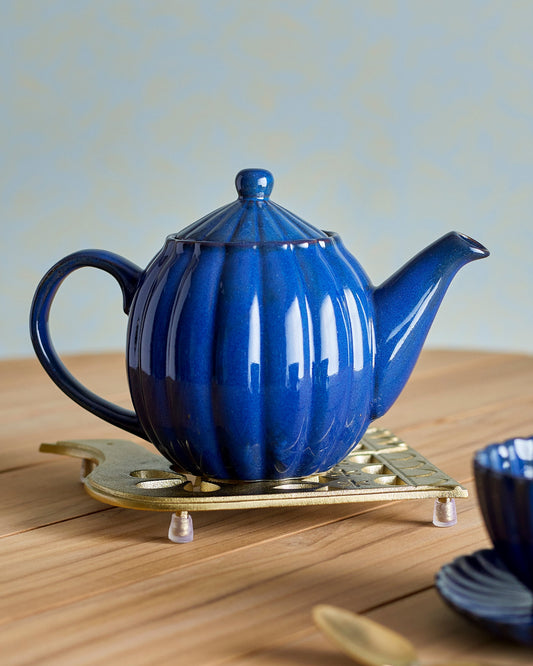 Blue teapot on a wooden surface with a light background