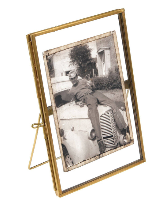 Gold photo frame with a black and white photo of a child on a car