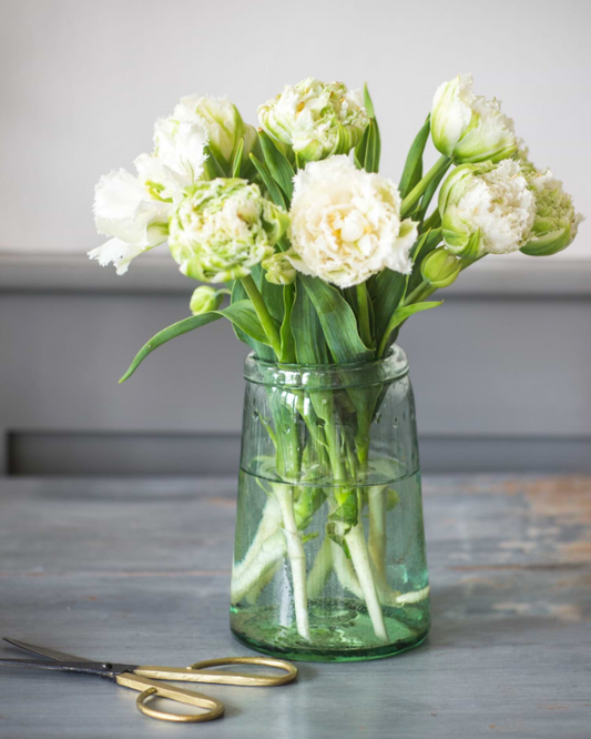 Clear vase with white flowers on a wooden surface