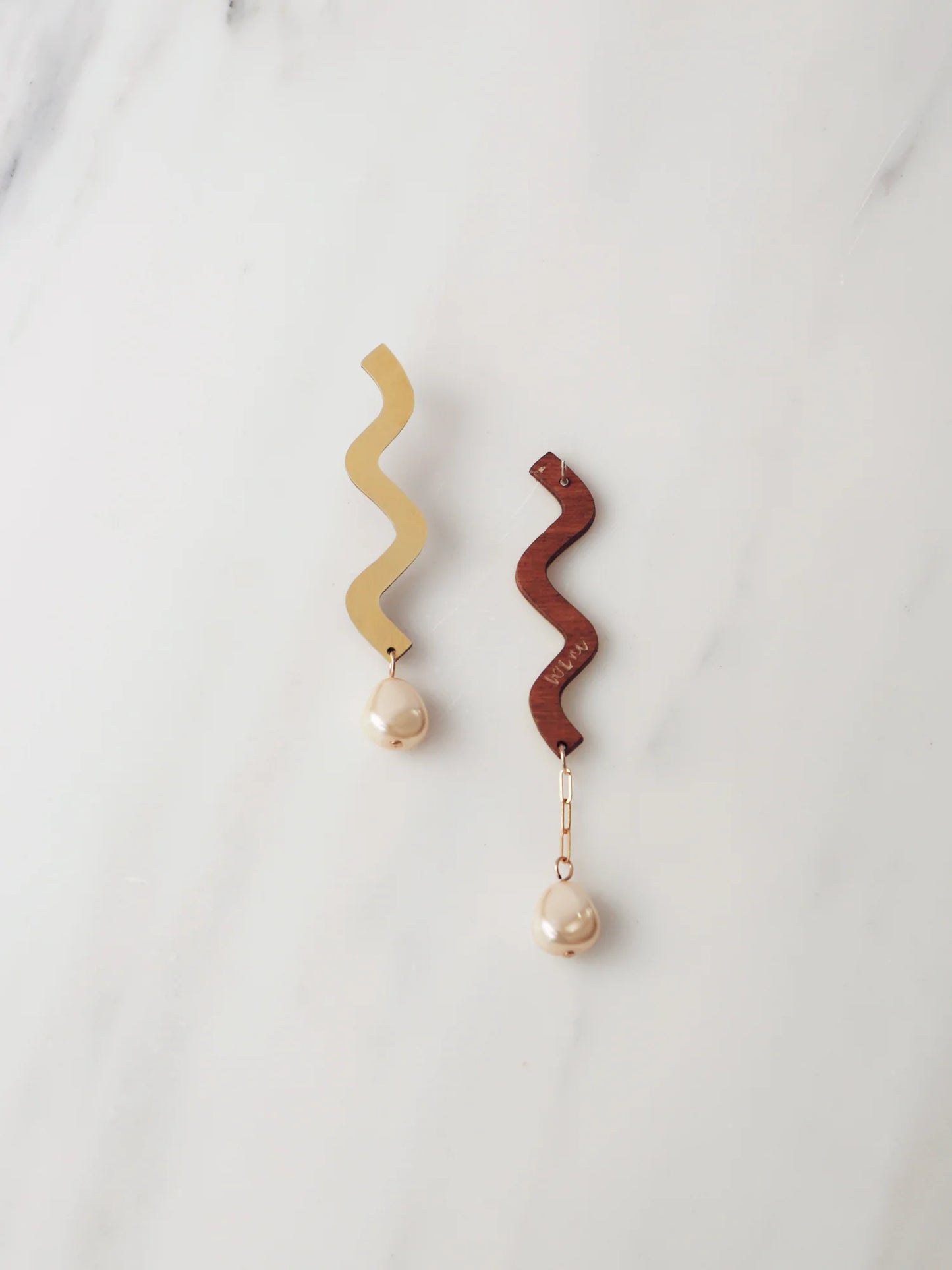 Front and back of Martha asymmetric brass and pearl earrings by wolf and moon