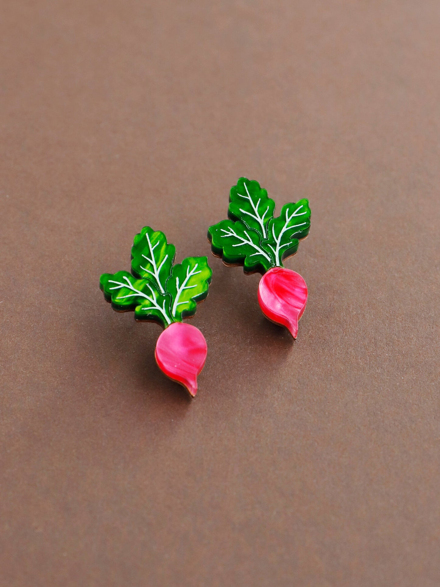 Acrylic realistic radish studs from Wolf&Moon on brown background