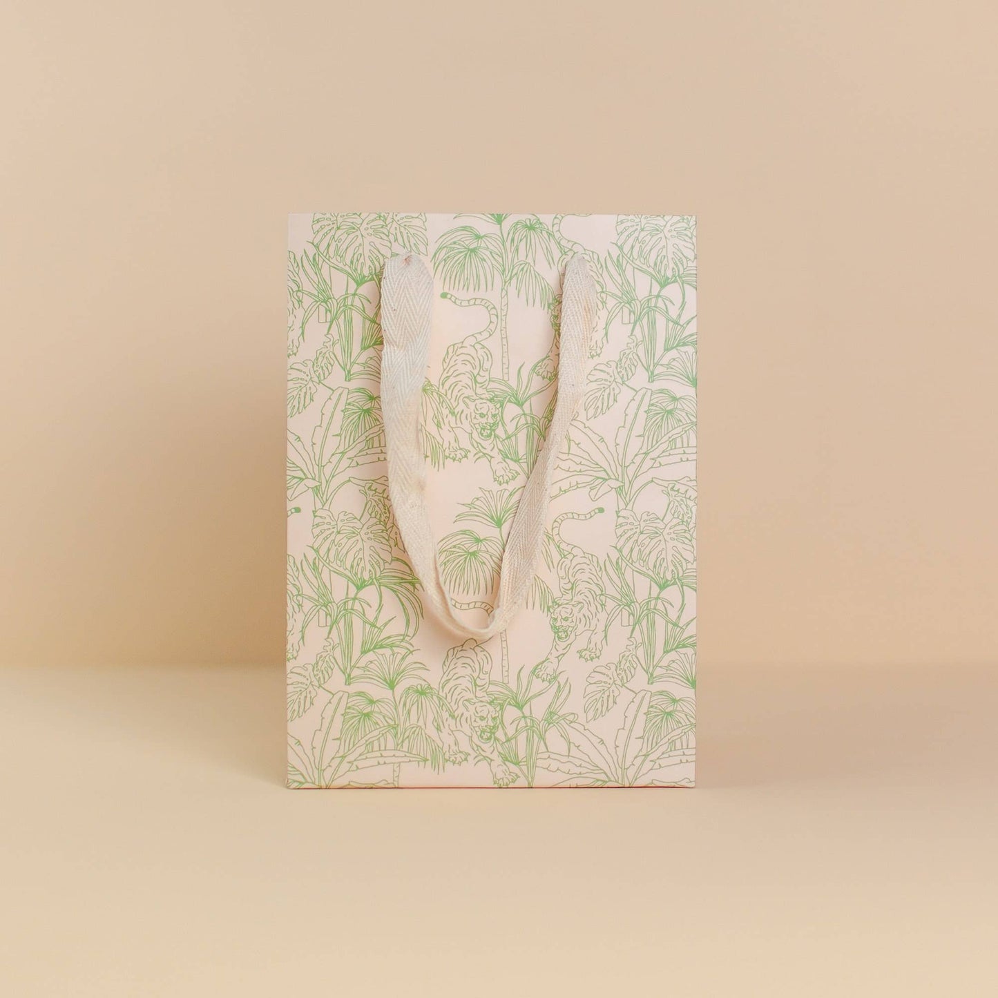 Pale green, jungle print gift bag by Cai & Jo is plastic-free and zero waste. Nontoxic, plastic-free, reusable, and includes speckled cotton handles.
