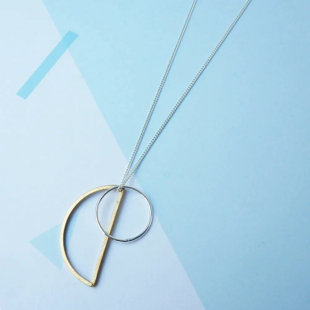 The Every Space Locus necklace with sterling silver chain, and brass and silver geometric charms by Custom Made UK