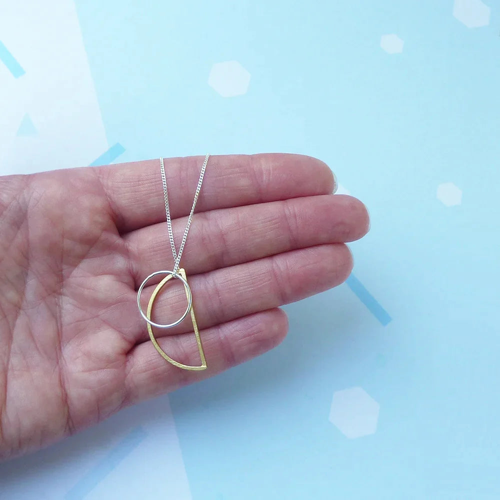 The Every Space Locus necklace with sterling silver chain, and brass and silver geometric charms by Custom Made UK