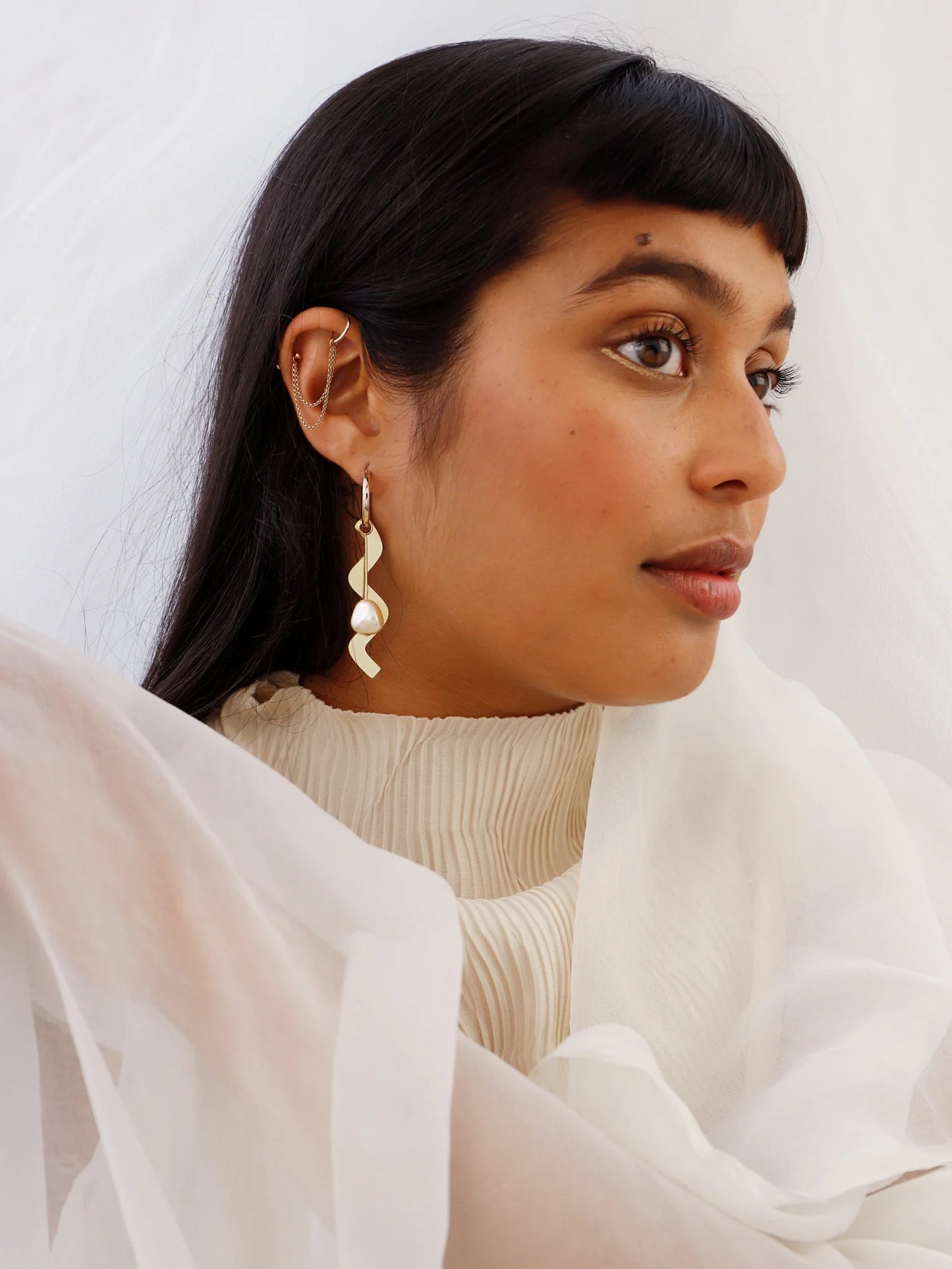 The Every Space mismatched Martha hoop earrings with gold filled hoops and emerald & brass charms by Wolf & Moon