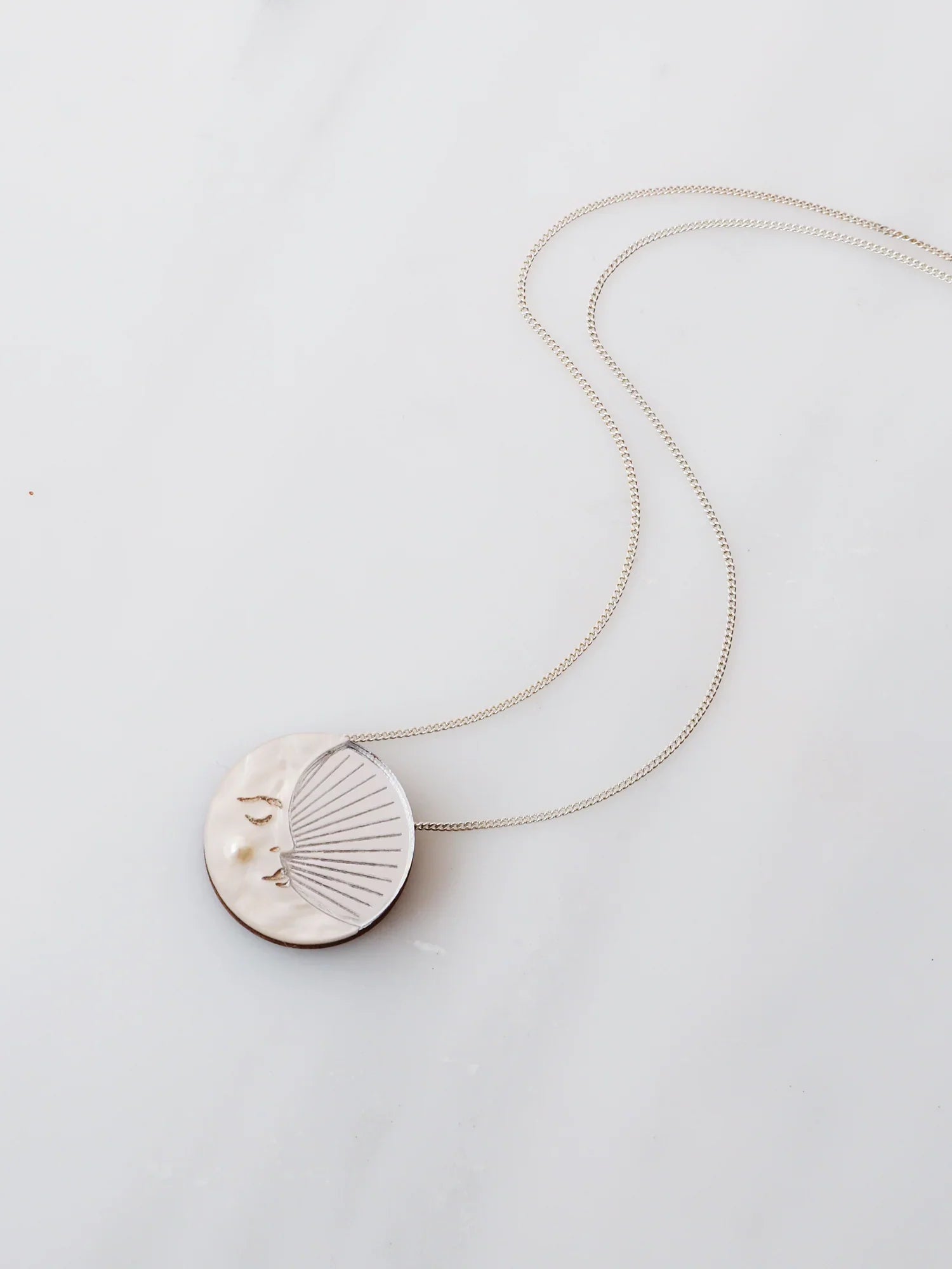 Silver Crescent Moon Necklace by wolf and moon in acrylic on table