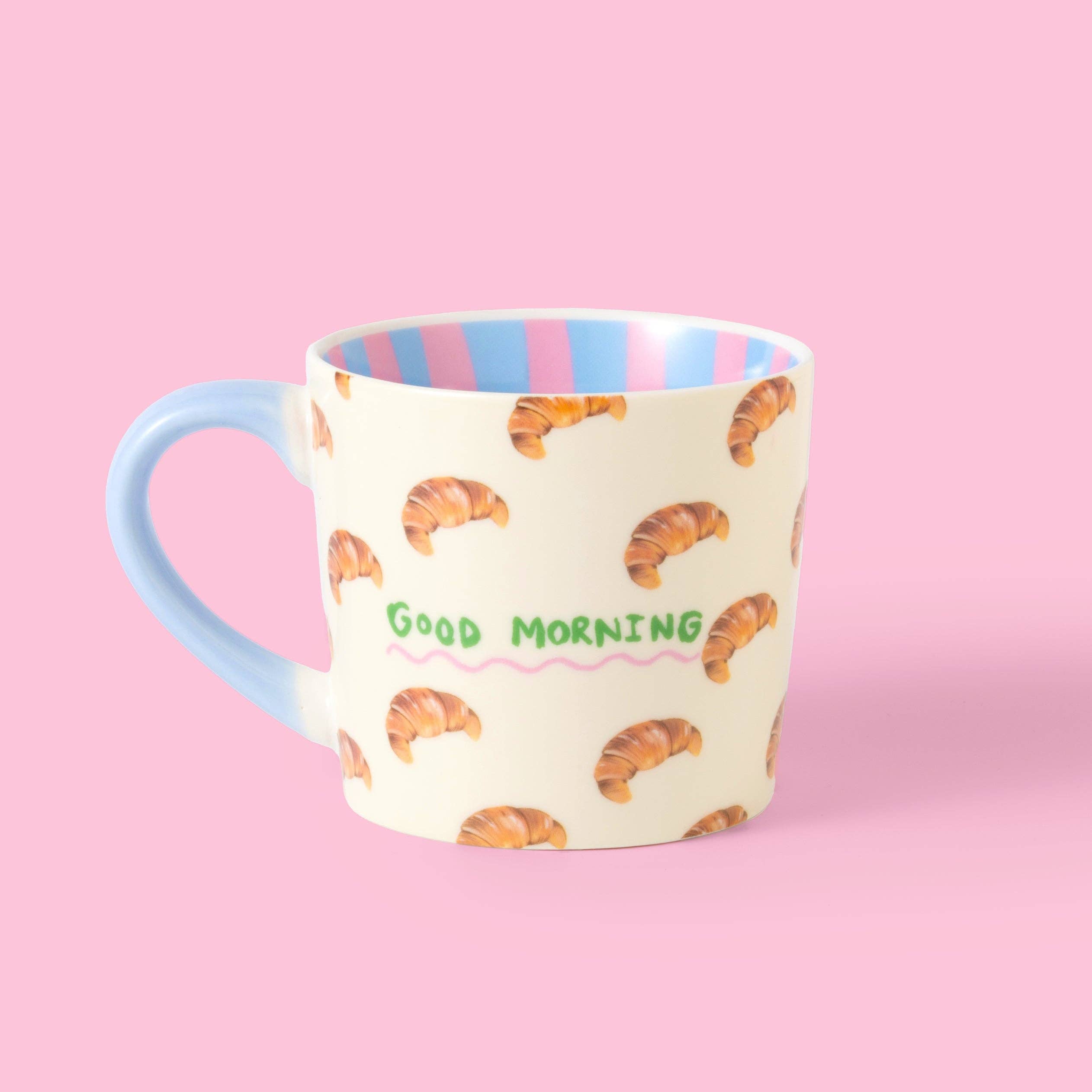 Mug with croissant pattern and 'Good Morning' text by Eleanor Bowmer, on a pink background