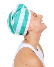 Woman wearing a green and white striped headswrap on a white background