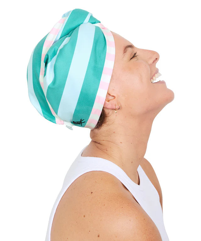 Woman wearing a green and white striped headswrap on a white background
