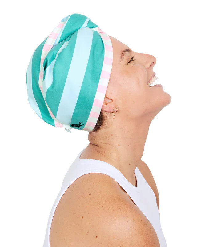 Woman wearing a green and white striped headswrap on a white background