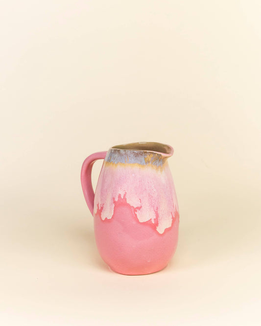 Pink ceramic pitcher on a beige background
