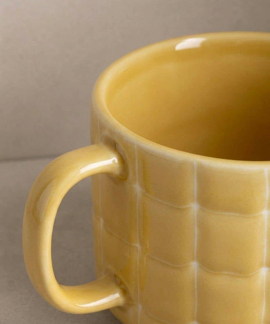 Egg Back Home yellow mug with textured surface on a neutral background