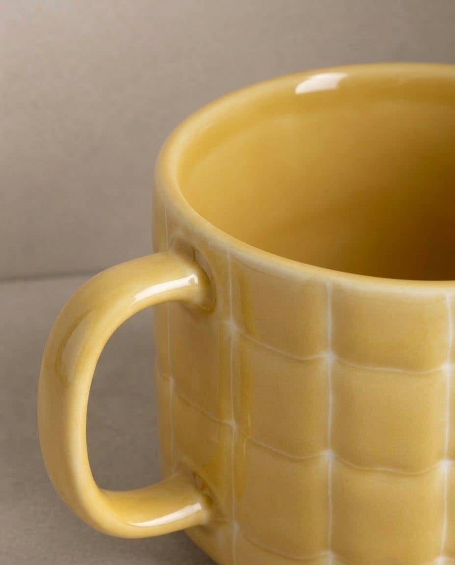 Egg Back Home yellow mug with textured surface on a neutral background