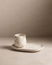 Egg Back Home white ceramic jug with multicoloured speckles on a tray against a beige background