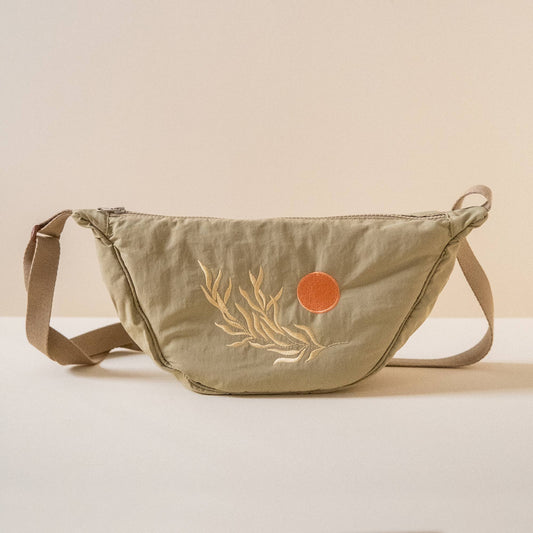 Green sling bag with beige leaf design and orange circle embroidered