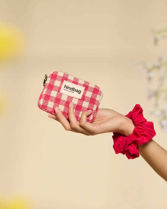 Hand holding a red and white checkered cotton purse with 'hindbag' branding