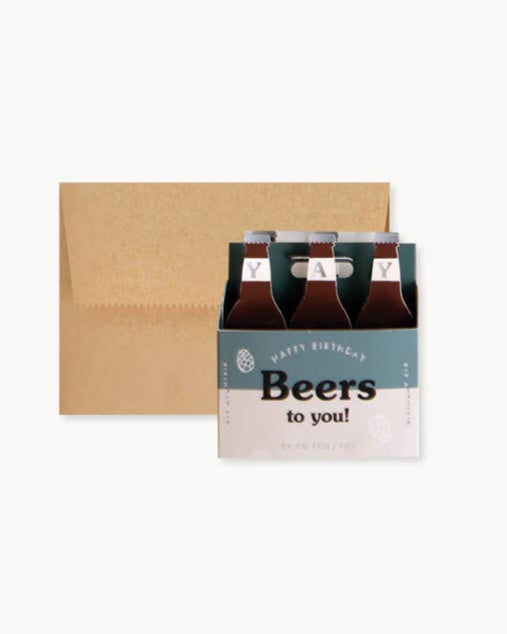 Six-pack of beer with a 'Happy Birthday Beers to you!' card on a white background