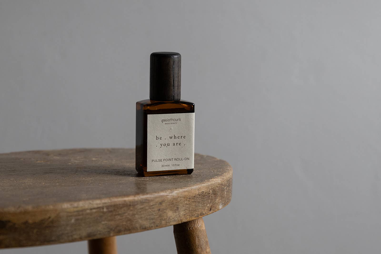 Be Where You Are pulse point roll by Quiet Hours, in an amber bottle on a wooden stool