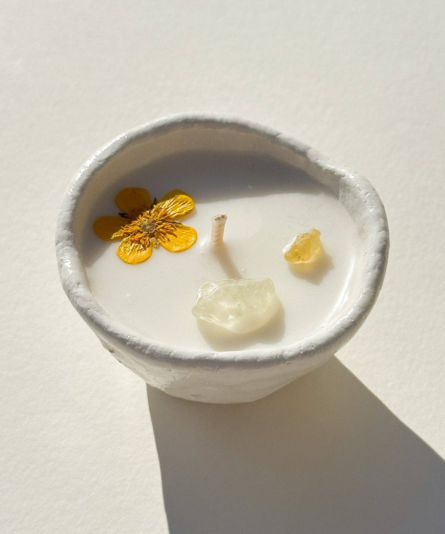 Burning Bright Abundance candle with citrine crystal and buttercup topping