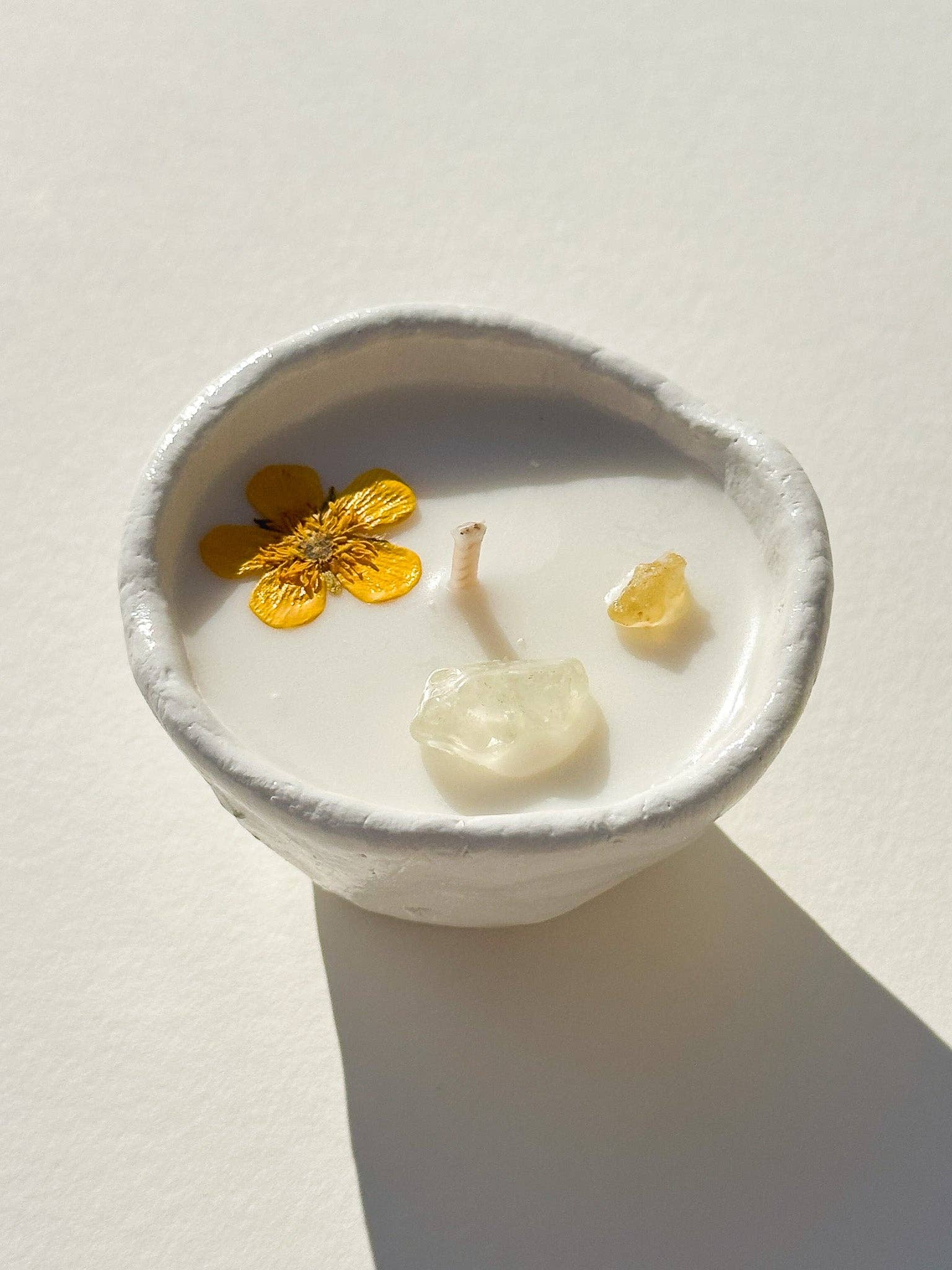 Burning Bright Abundance candle with citrine crystal and buttercup topping