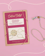 Cotton Twist friendship bracelet kit with a completed bracelet on a pink background