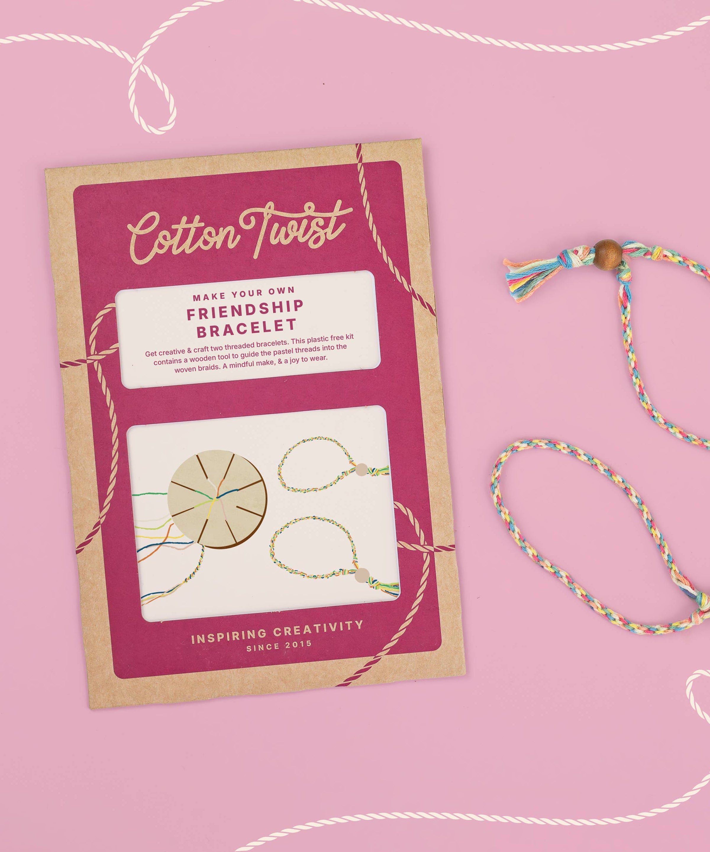 Cotton Twist friendship bracelet kit with a completed bracelet on a pink background