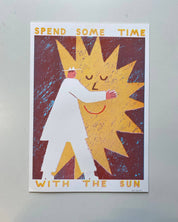 Poster with a stylized illustration of a person embracing the sun and text 'Spend some time with the sun' on a plain background.
