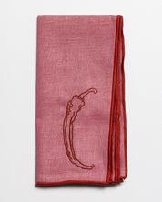 Close up of the embroidered chilli design on a linen napkin