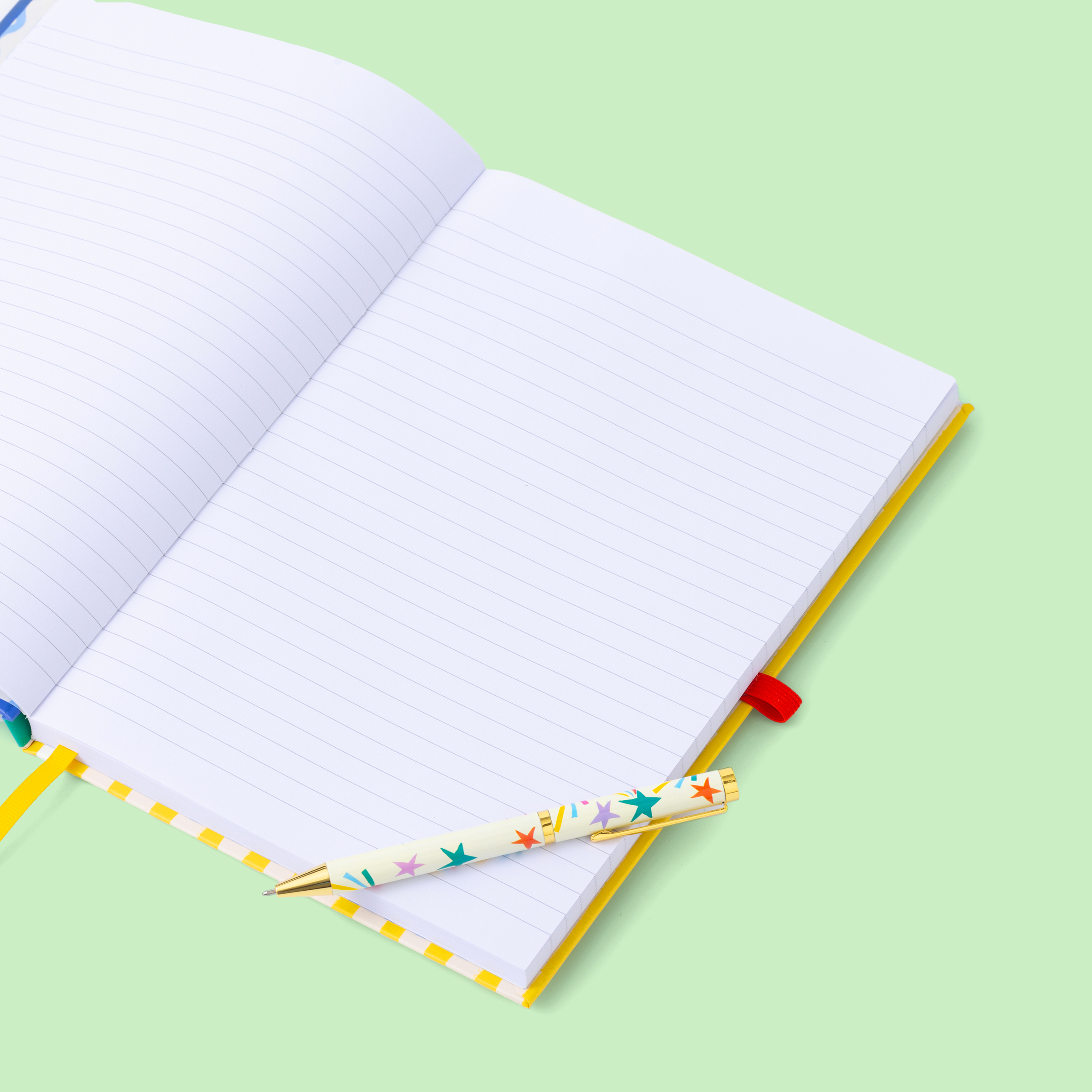 Open notebook with a colorful pen on a light green background