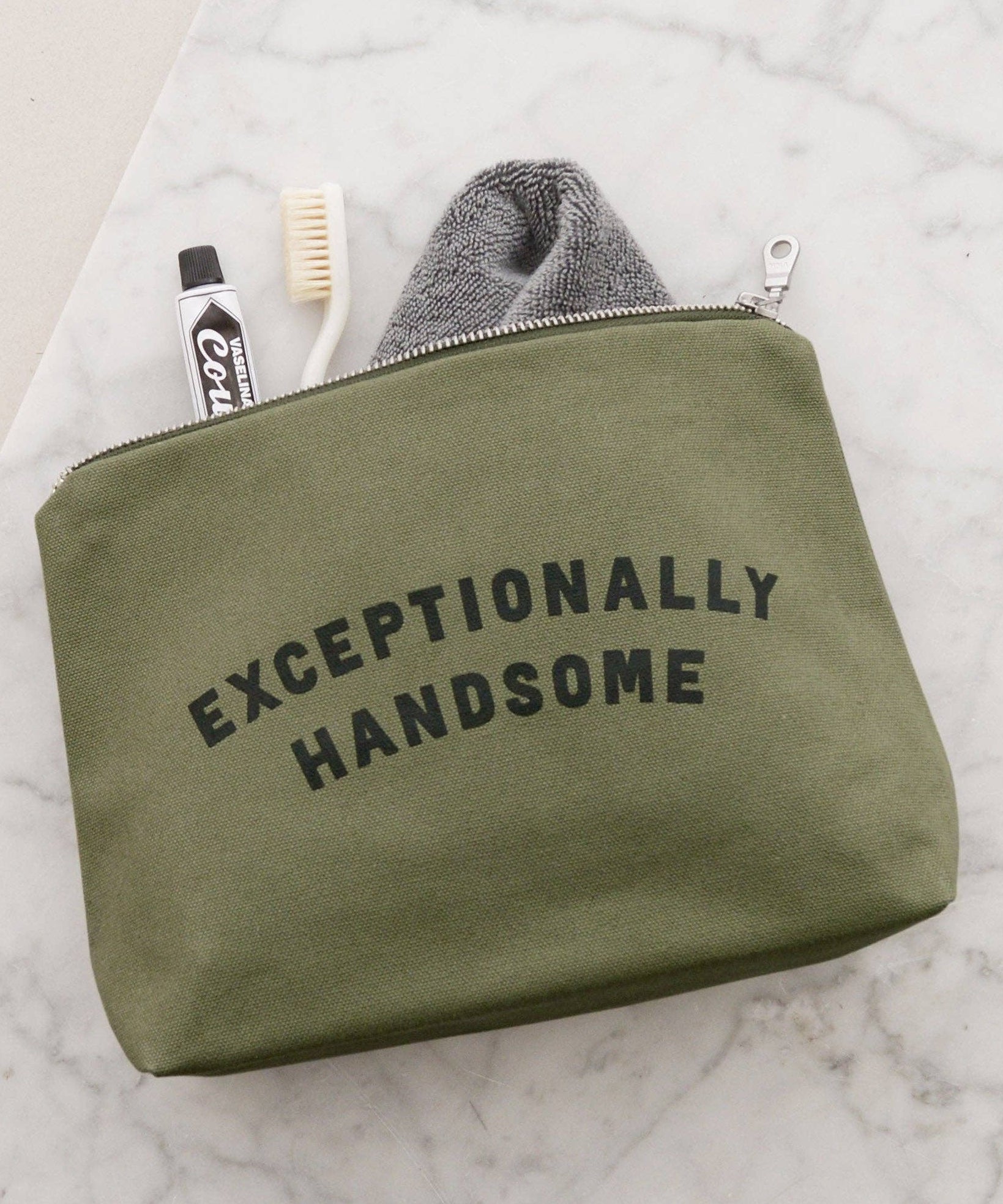 Green pouch with 'Exceptionally Handsome' text on a marble surface