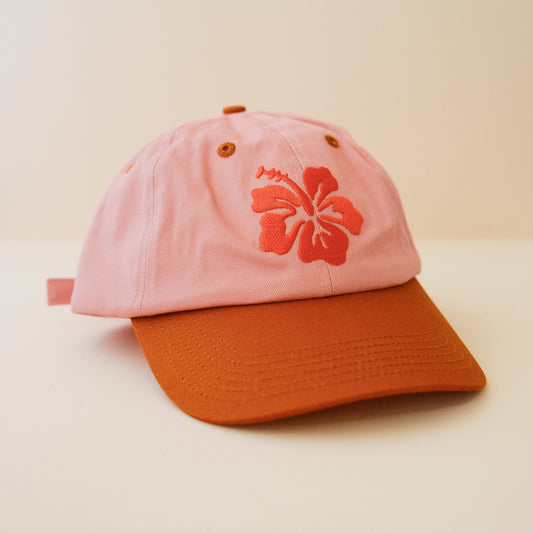 Pink and burnt orange cap with an embroidered hibiscus design 
