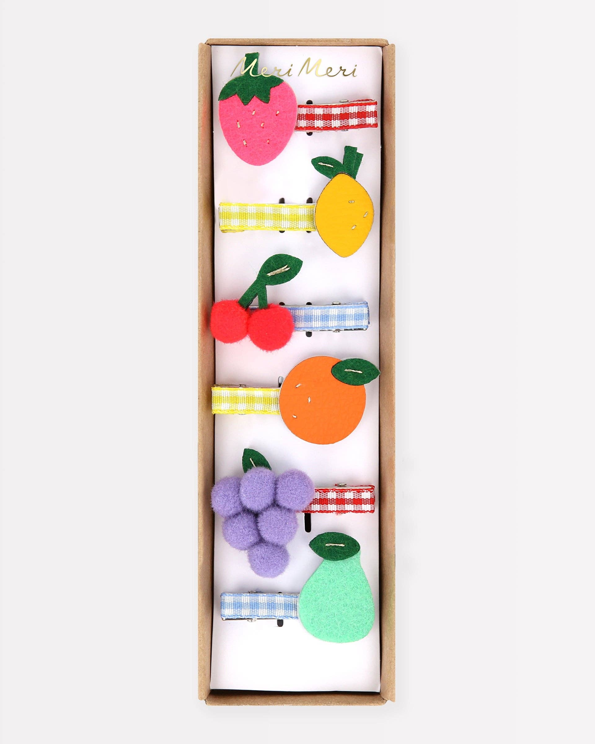 Box of colorful fruit-themed hair clips on a white background