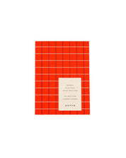A rectangular red-orange notebook with a white label in the center reading 'notem' and smaller text above, shown on a plain white background.