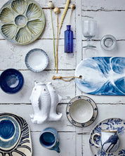 Collection of ceramic dishes and decorative items on a wooden surface