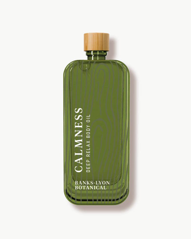 Green bottle of 'Calmness' body oil with a wooden cap on a white background