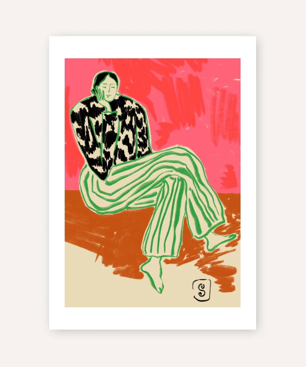 A framed art print featuring a stylized illustration of a seated person in a black-and-white patterned top and green striped pants, set against a pink and rust background with a beige lower section.