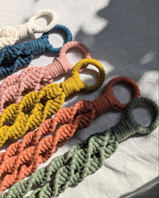 Set of colorful braided macrame plant hangers on a light background