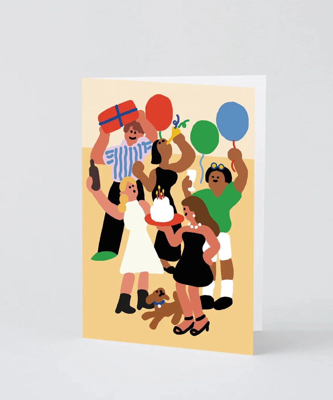 A vertical greeting card featuring a colorful, minimalist vector illustration of a birthday party scene with people, balloons, a cake, and a dog, shown standing against a light gray background.