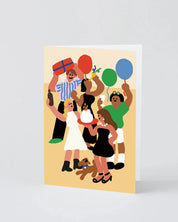 A vertical greeting card featuring a colorful, minimalist vector illustration of a birthday party scene with people, balloons, a cake, and a dog, shown standing against a light gray background.