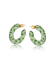 Green resin hoop earrings with dark green flecks and a brass butterfly