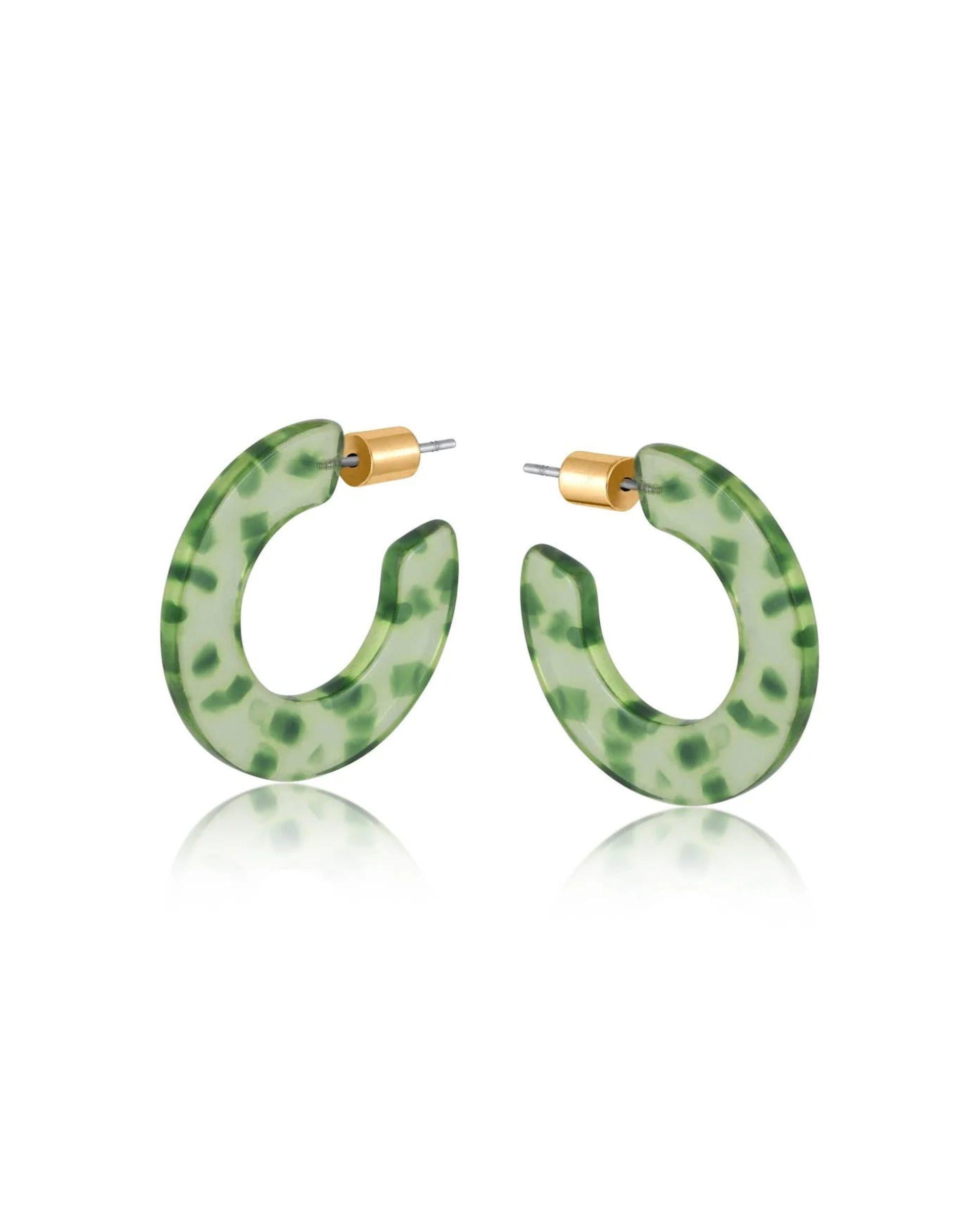 Green resin hoop earrings with dark green flecks and a brass butterfly