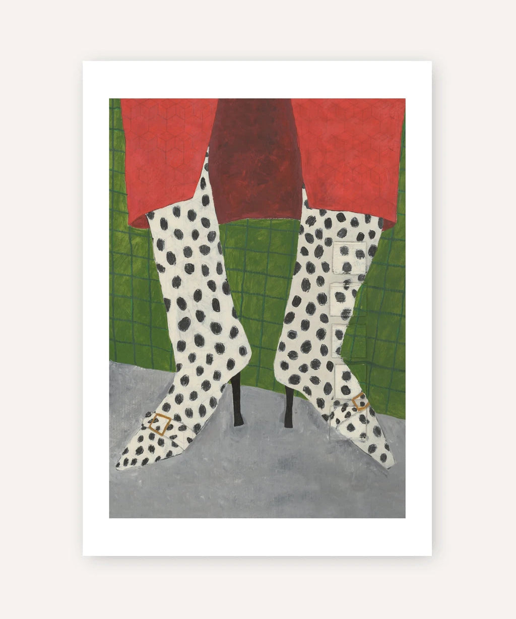 A framed art print featuring a stylized illustration of a person's legs wearing white high-heeled boots with black spots, red skirt hem, and a green grid-patterned background.