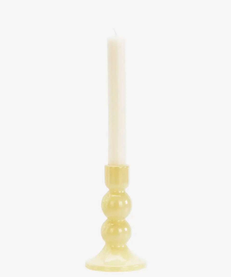 Candle in a yellow holder on a white background