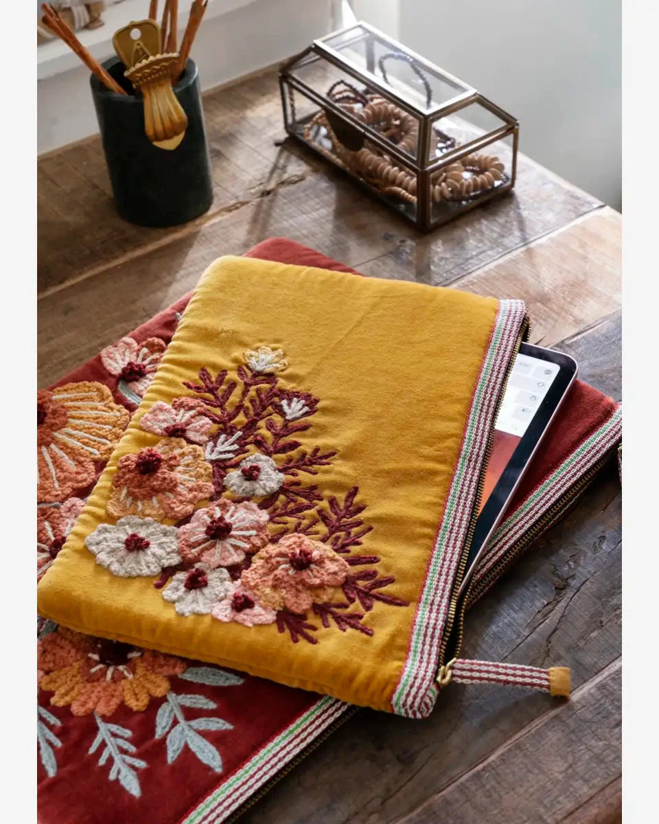Yellow embroidered blanket with floral patterns on a wooden surface