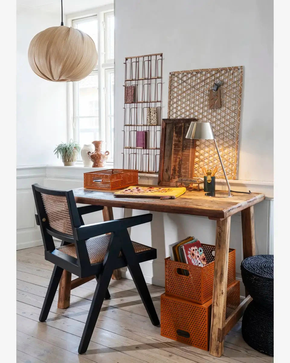 Wooden desk with black chair in a room with decorative elements