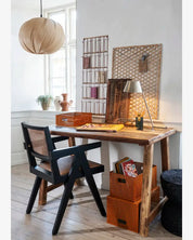 Wooden desk with black chair in a room with decorative elements