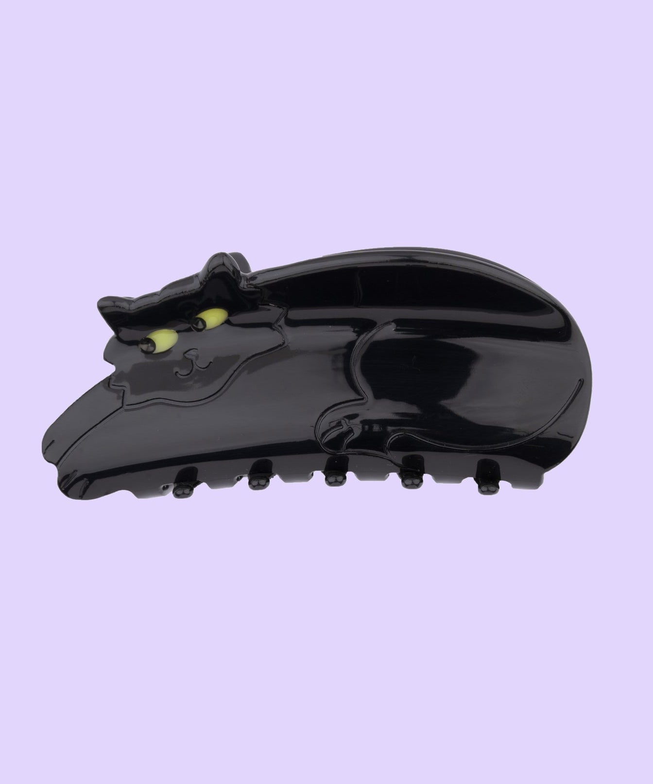 Black cat hair law with yellow eyes on a light purple background